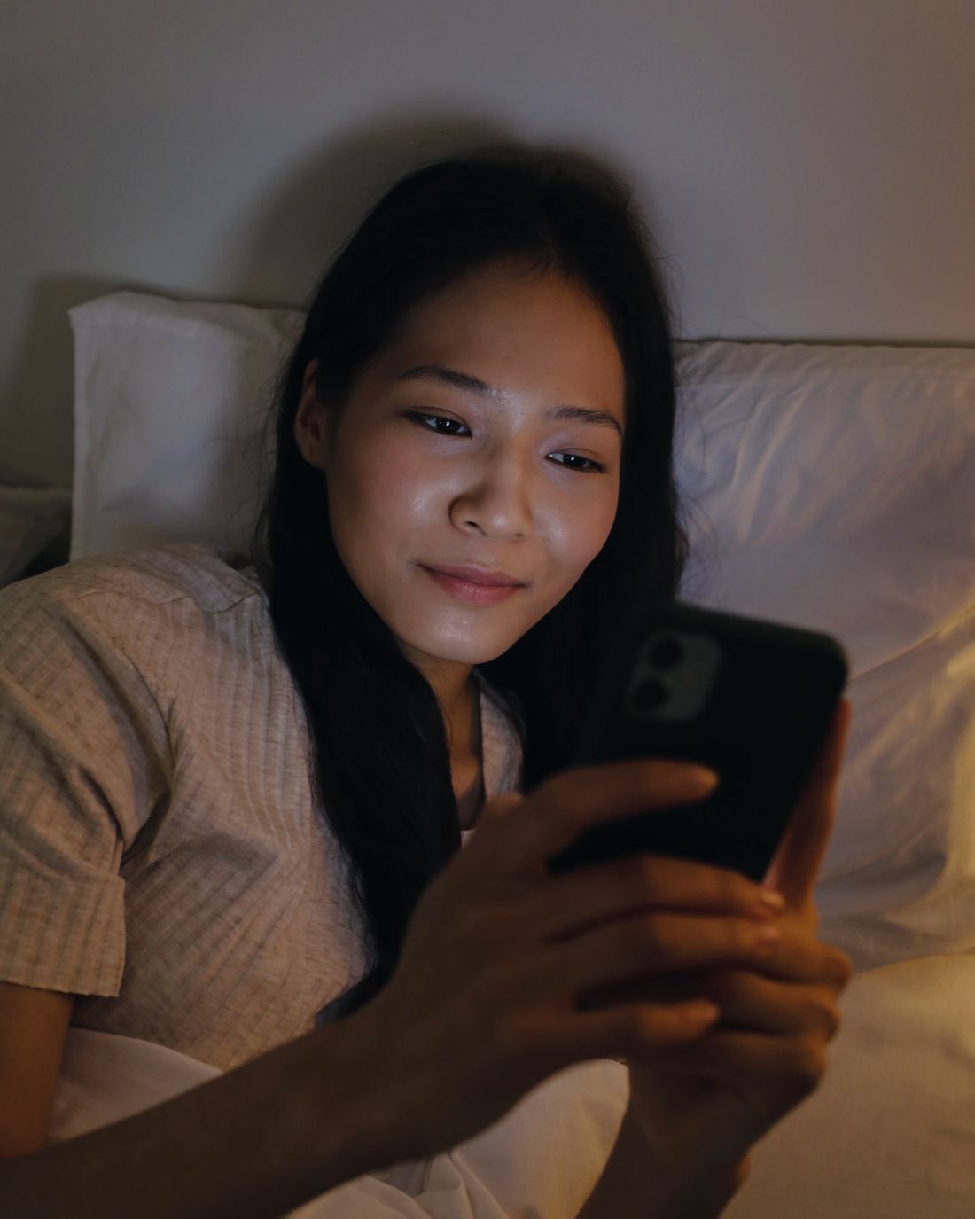 La stessa ragazza sorride leggendo il telefono
